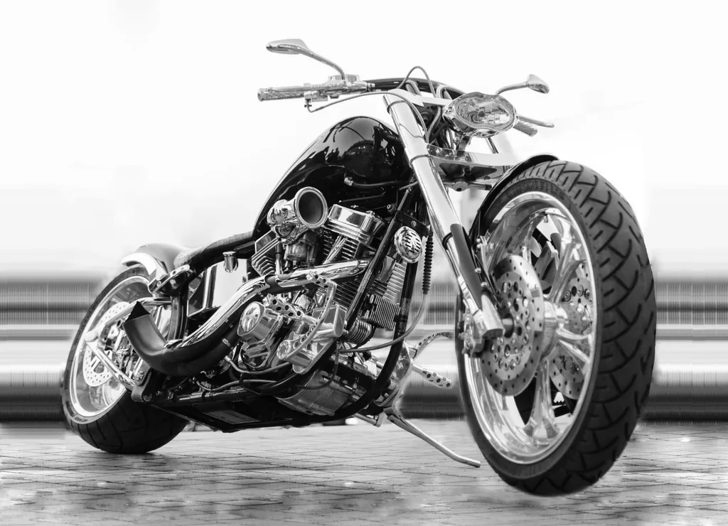 A custom chopper with chrome forks, a wide rear tyre and an exposed V-twin engine, parked indoors