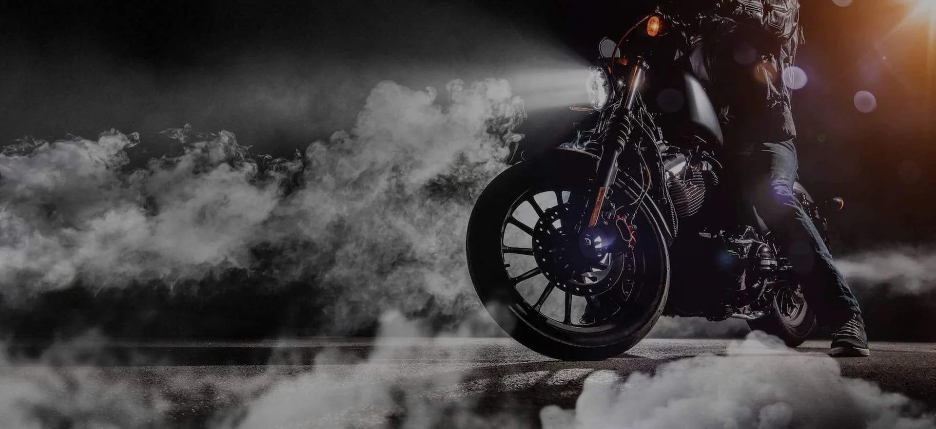 Motorcycle front wheel in smoke A motorcycle front wheel and fork lit through drifting smoke, in black and white