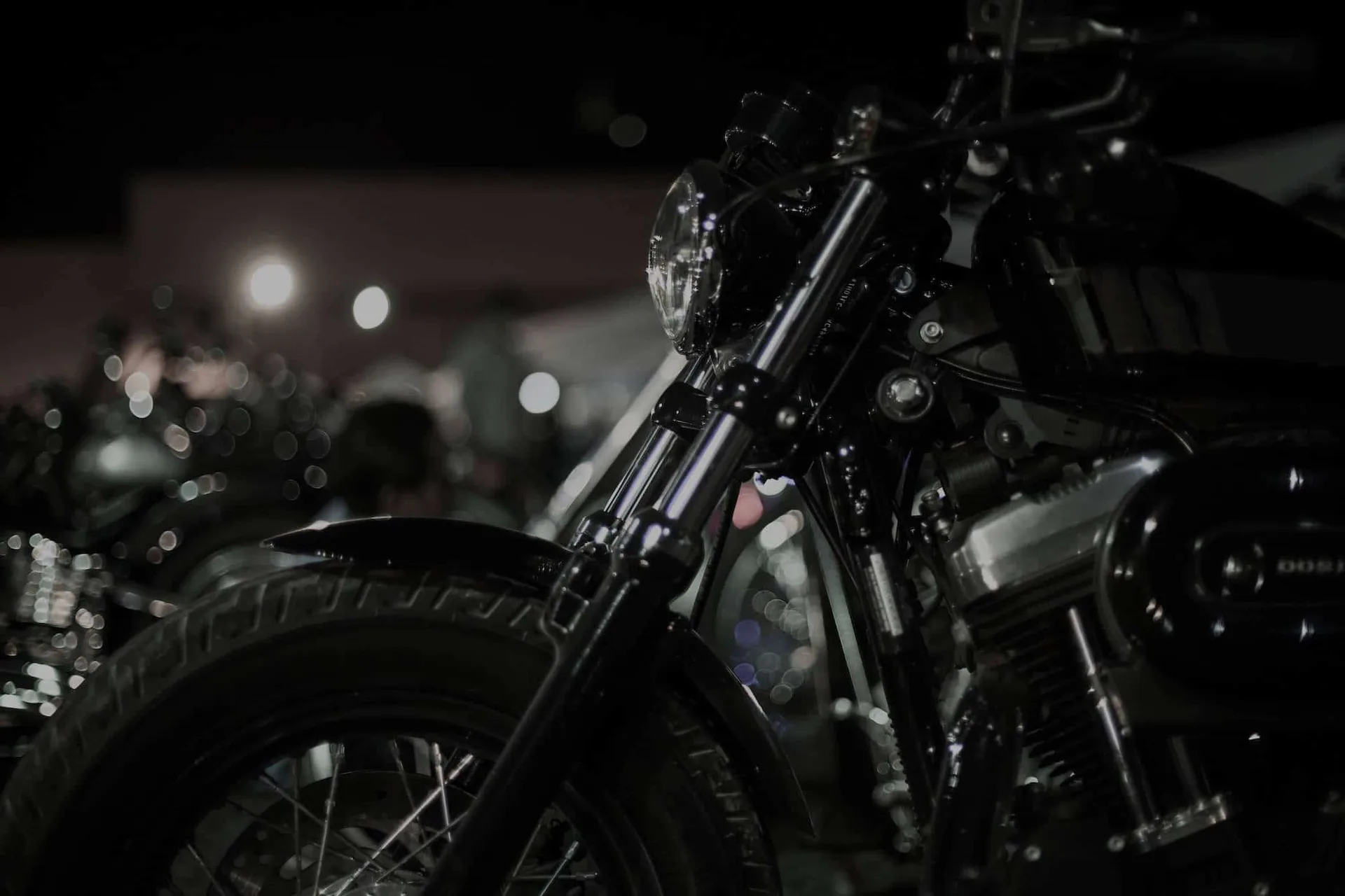 A row of motorcycles on display at an indoor show, shot with a shallow depth of field
