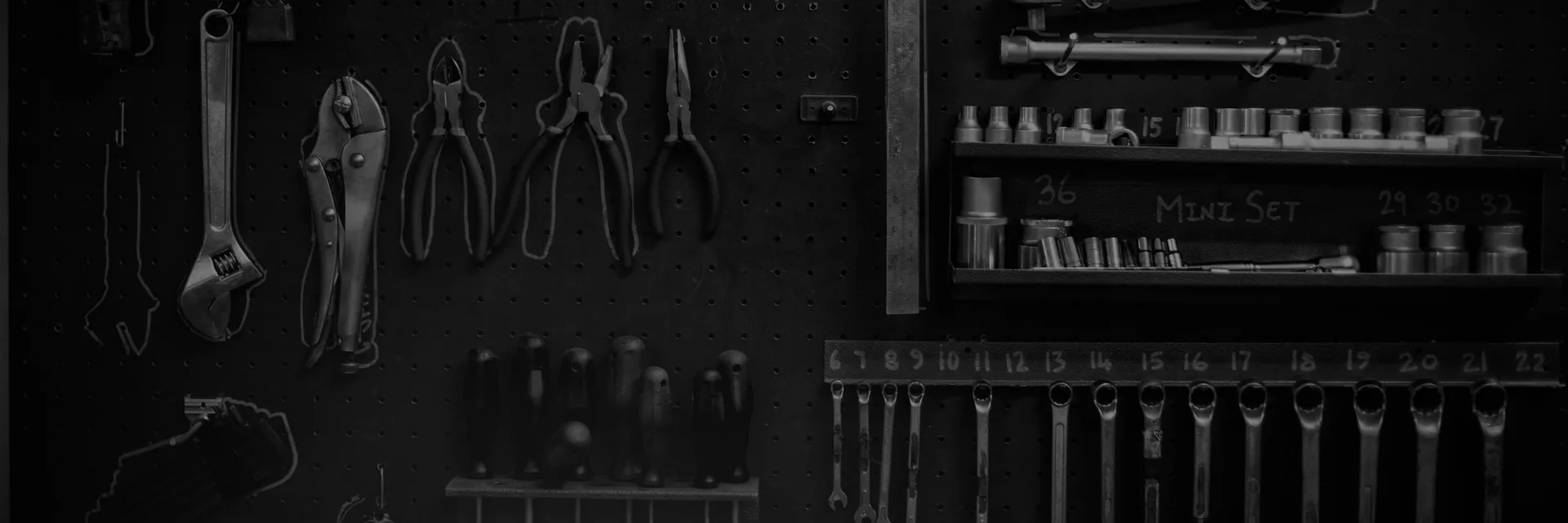 A workshop pegboard hung with spanners, pliers and sockets